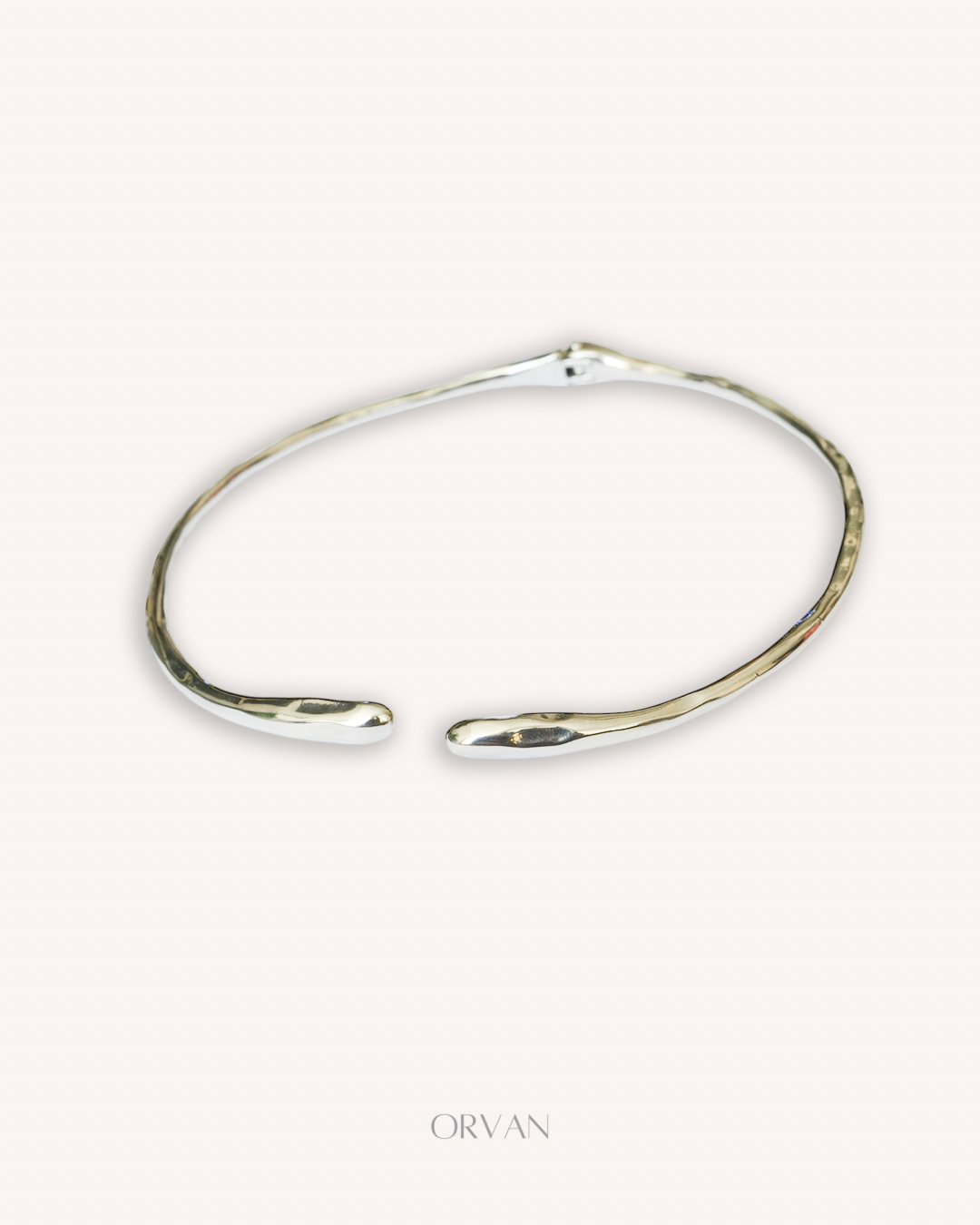 گردنبند نقره‌ای مینیمال روی گردن زن با پیراهن سفید